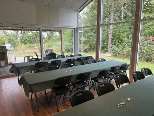 Havestue med langborde og udsigt til naturen